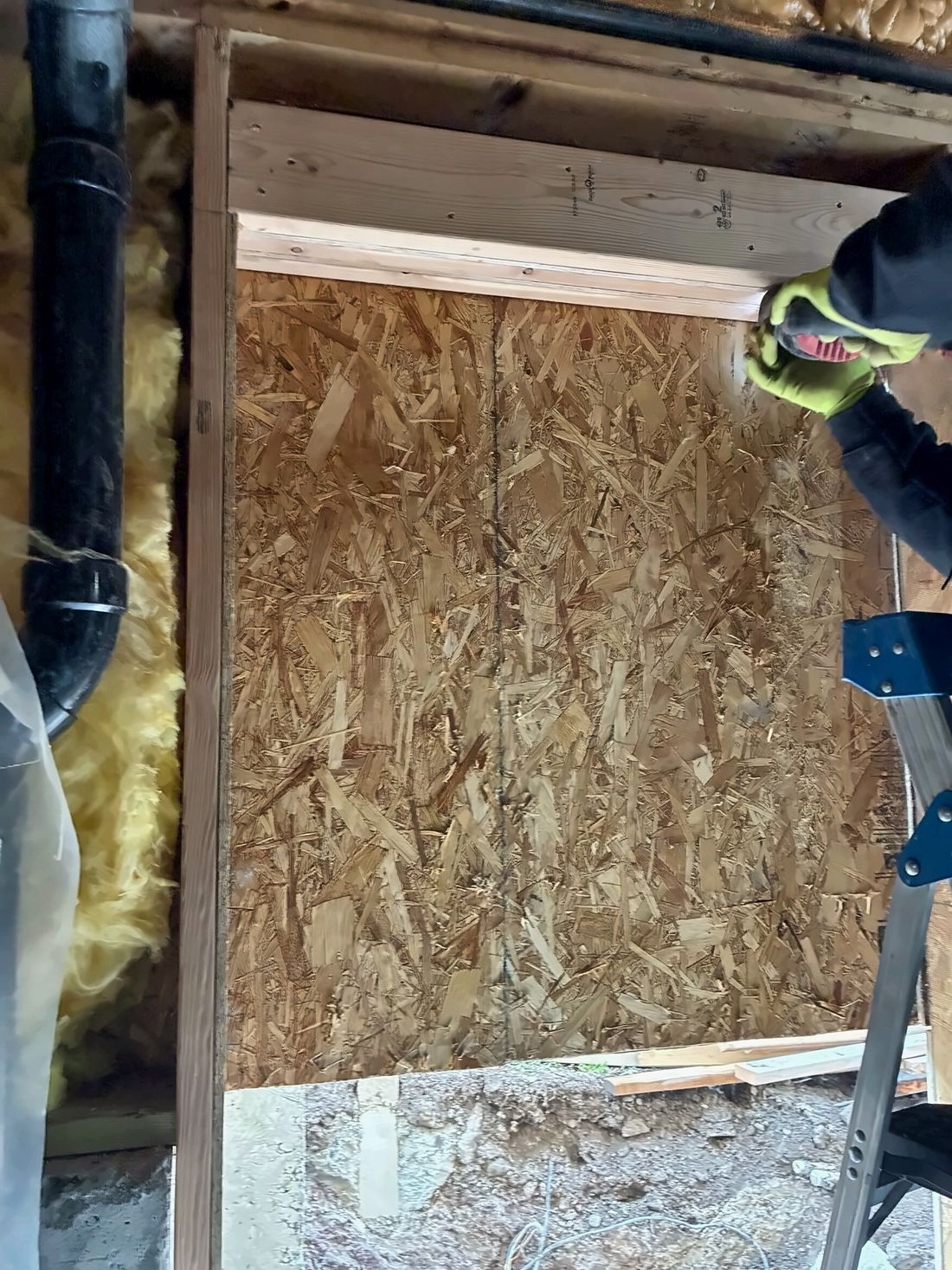 Carpenter framing a new exterior basement opening