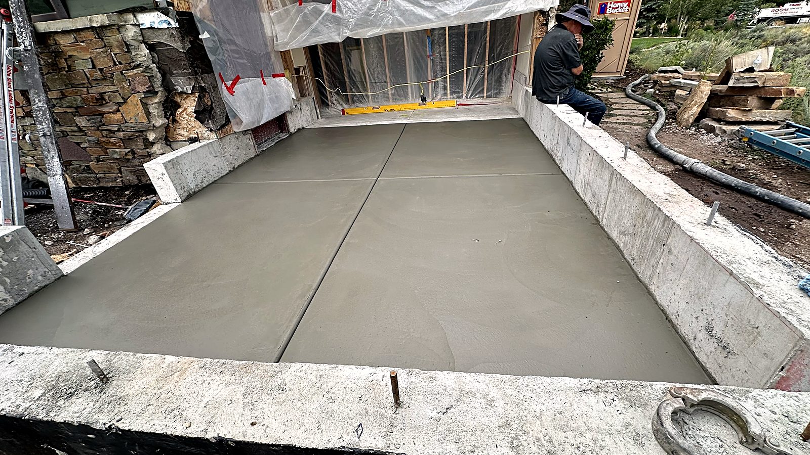 Wide concrete walkout entrance freshly poured between two foundation walls, Park City Utah